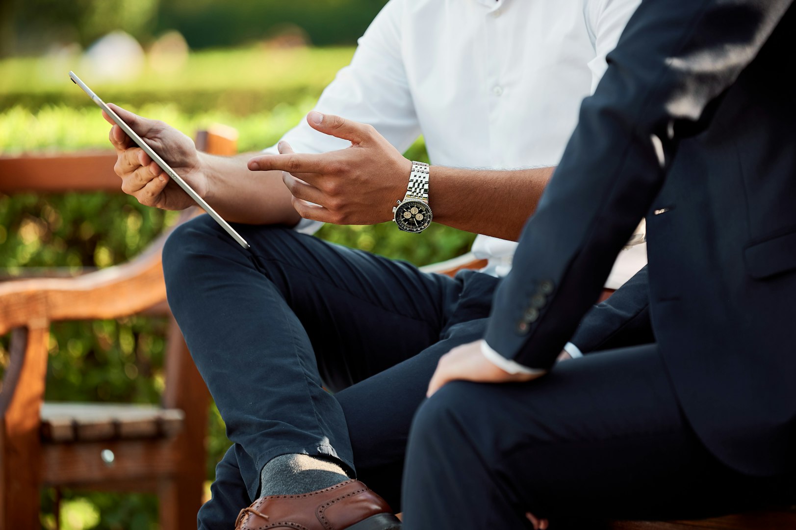 One man showing information on a tablet to another during a discussion.